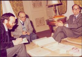 Paris Press Conference - Roger Jackson and two unidentified men sit around a coffee table consulting reports