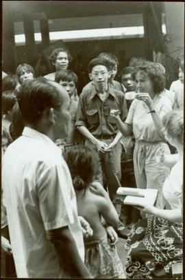 CUSO Mission, North-eastern Thailand - Unidentified woman in group lifts a cup in a demonstration