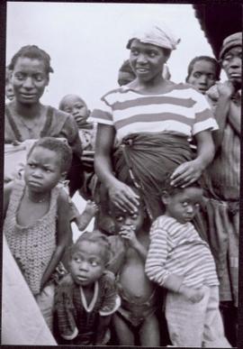 CUSO Mission in Waku-Kungo, Angola - Group of unidentified women and children look at something out of frame