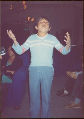 W.H.O. Trip, Ayacucho, Peru - Unidentified boy raises his arms in a living room