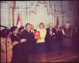 Ten unidentified men and women clap as a government minister presents the Nisga’a Final Agreement to a Nisga’a chief?, 1999