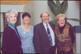 Iona Campagnolo, Jean Weller, Geoffrey R. Weller, and Addie Milewski stand, smiling, in the Atrium of the Administration building, UNBC