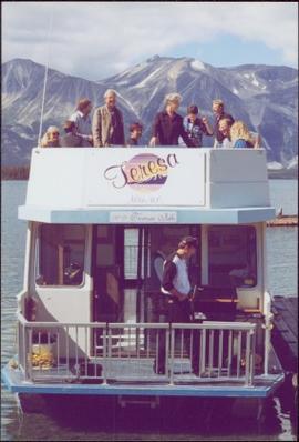 Chancellor's Tour - Iona Campagnolo stands with group on upper deck of the 'Theresa' houseboat in Atlin, BC