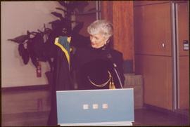 Chancellor's Farewell  - Iona Campagnolo holding chancellor's regalia from behind podium
