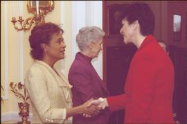 Governor General Michaëlle Jean shaking hands with an unidentified woman wearing a red suit, Lieu...