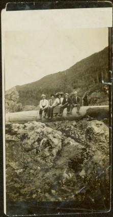 Sarah Glassey Sitting with Men on Log over Canyon