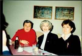 Iona Campagnolo sitting between two unidentified women at a restaurant