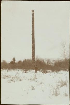 Young W.E. Collison standing by totem pole, Queen Charlotte Islands, BC