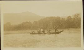 Eight unidentified men poling a canoe up Nass River, BC