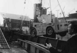 Dismantled fork truck in sling in a Sydney harbour