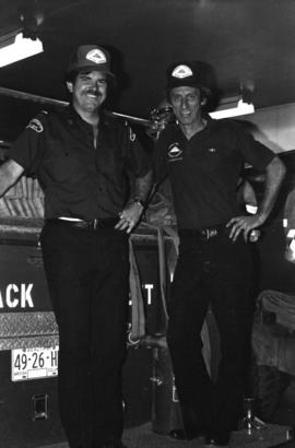Two firemen in front of a fire truck