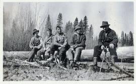 Several men sitting on a log