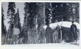 Several men with snow shoes and a dead animal