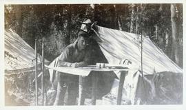 Man reading a map in front of a tent