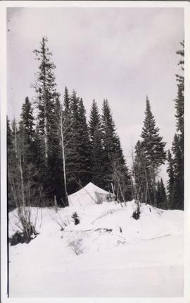 A tent perched on a snowy hill top