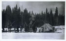 Several men standing around a campsite