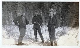 Three men standing upon the snowy ground