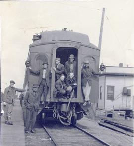 Several men on the back of a train car