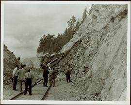 Bulldozer removing rock debris from train tracks