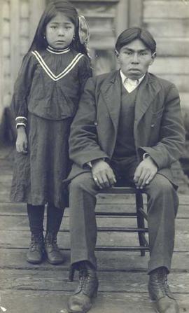 Two young, unidentified Indigenous siblings posing for a portrait at a Christian Mission