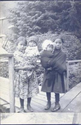 Two First Nations girls holding two infants
