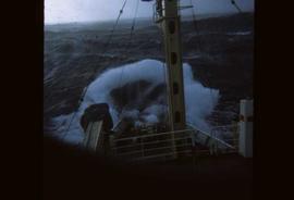 A weather ship hitting a wave in rough weather