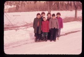A group of children standing on a snow-covered road