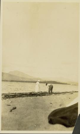 Unidentified man and woman walking along a lakeshore