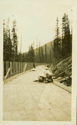 Construction of a wood planked flume around the side of a mountain