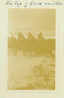 Men and supplies aboard a two horse driven sleigh on top of Bald Mountain in the winter