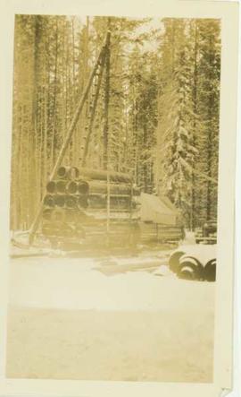 Large sled carrying freight into a mining (?) camp in winter