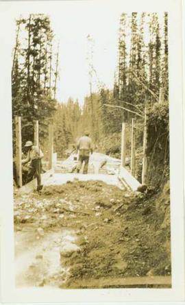 Two men working on flume construction