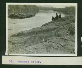 Three men sitting on the rocky banks of the Nechako River