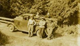 Six unidentified men posing for a photo in or by a truck next to the bridge over Little Qualicum River