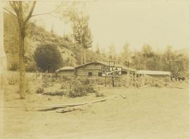 Peace River log cabin featuring two signs 