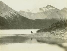 Man on horseback standing on the shore of Moberly Lake