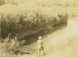 Carrol Paul fishing along the banks of a creek