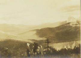 Prentiss Gray standing with his horse against a backdrop of forest covered mountains