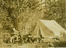 Dan Mosher (?) sitting beside a tent at Camp No.5