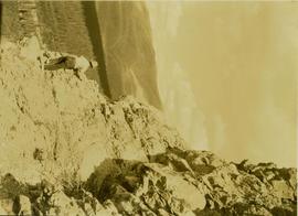 Unidentified man scaling a cliff in search of game
