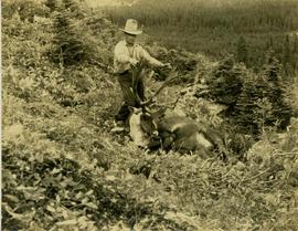 Pete Callao holding up the head of a felled caribou 
