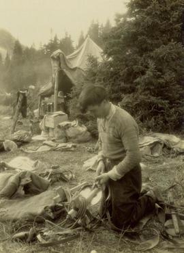 William Taylor repairing a pack saddle at camp