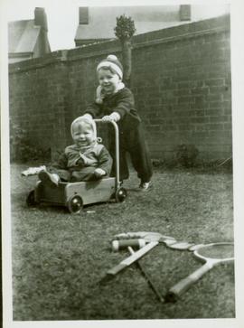 Family photographs from England: John pushing Christine in a wagon