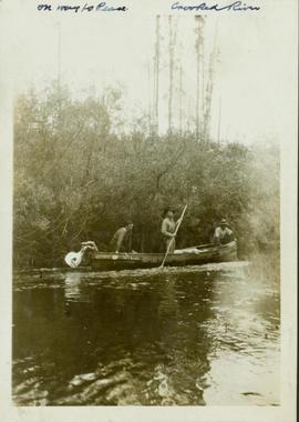 Three men in a boat being poled up the Crooked River