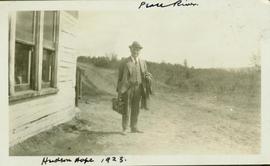 HGT Perry standing with coat and briefcase in hand on a dirt road in Hudson Hope, BC