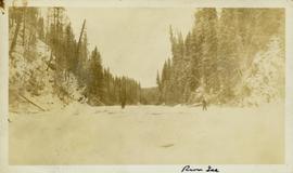 Two unidentified men standing on a frozen river
