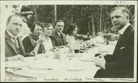 Harry Perry sits with Mrs. Perry, Mrs. Parker, T.D. Pattullo, Mrs. McLean and Alex Manson at a picnic table at a Liberal Party picnic
