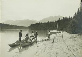Men with boat pulled up to a sandy bank along the Fraser River