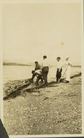 Four men and one woman standing along a lakeshore