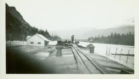 Two unidentified men surveying the flood waters at or near the Pacific Station on the Skeena River
